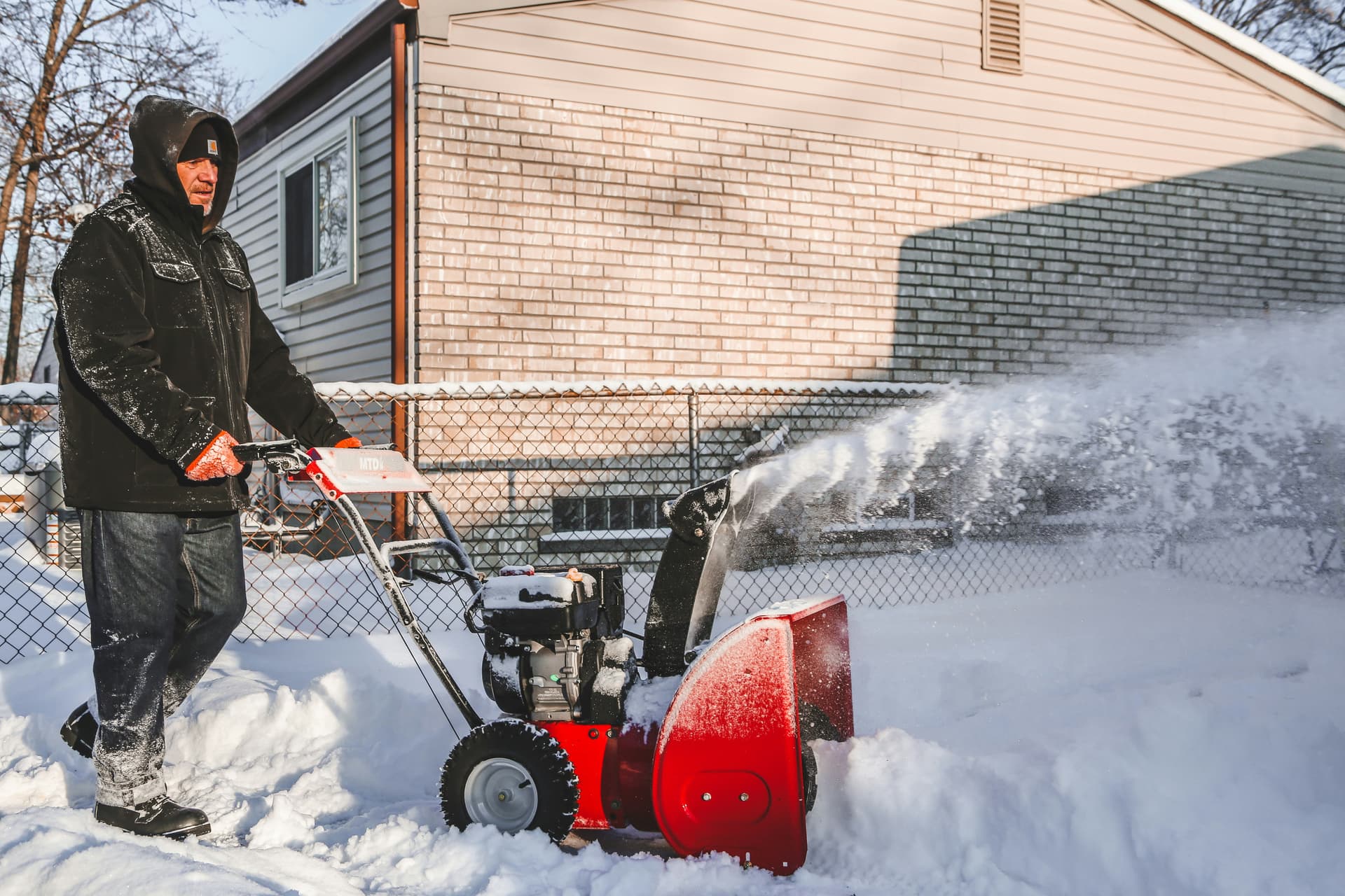 Snow plow clearing a residential driveway in Toronto